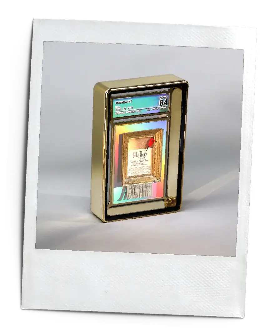 A gold PiggyBanx slab case holding a framed Bill of Rights